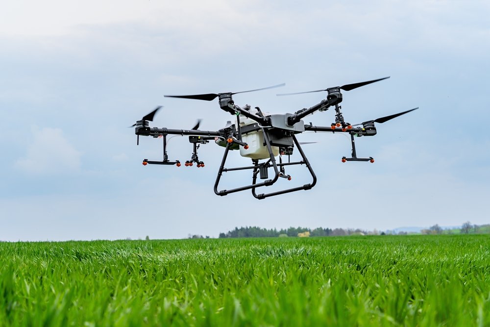 Drone,Flying,Over,A,Green,Grass,Field,With,Cloudy,Sky
